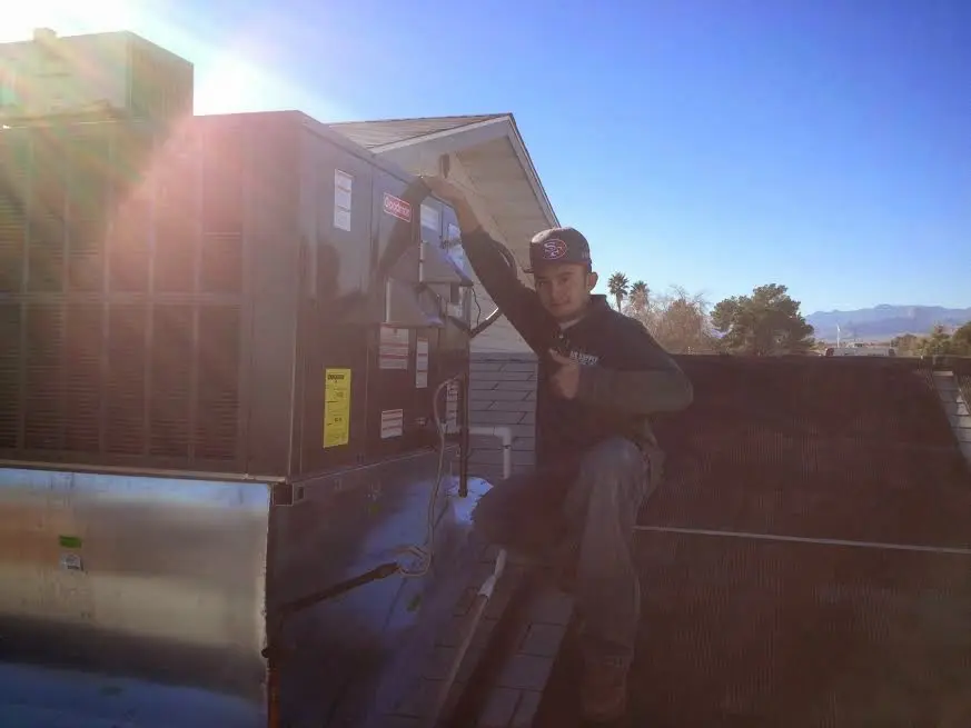 HVAC technician performing Heat Pump Repair on a rooftop unit in Batesville